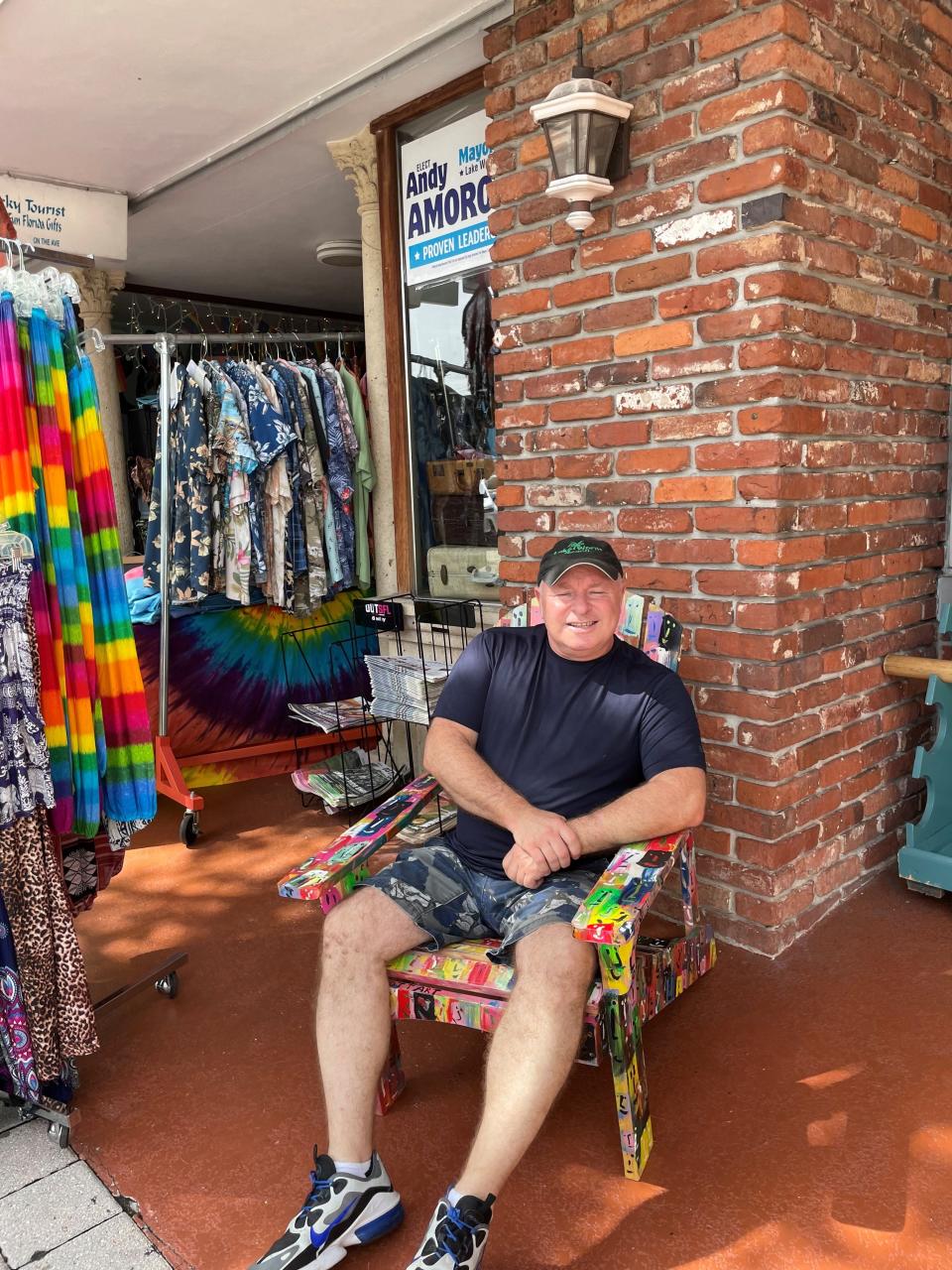 Andy Amoroso, owner of The Tacky Tourist and former Lake Worth Beach vice mayor relaxes in front of his store in a hand-painted Adirondack chair.