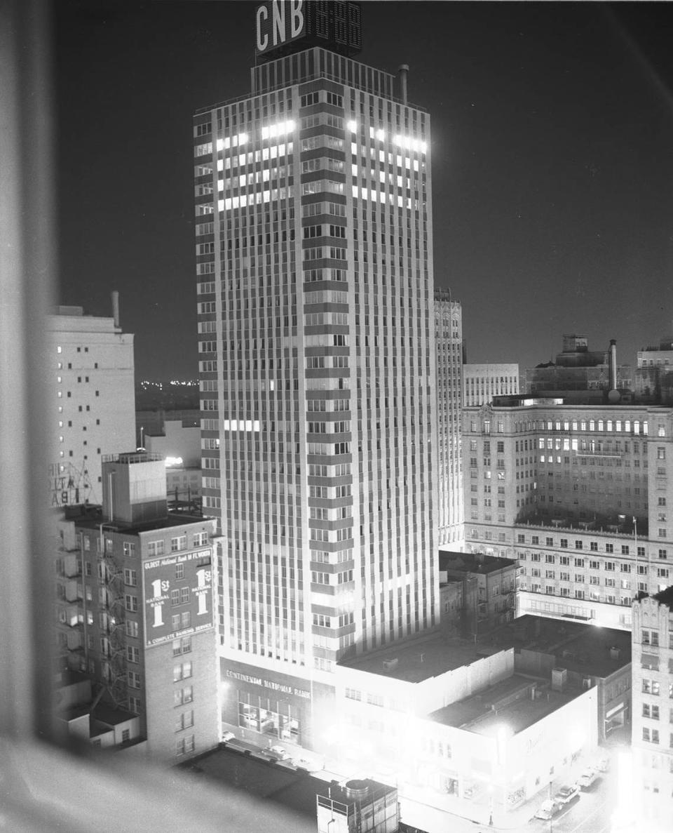 1957: Continental National Bank lighted at night, 09/28/1957