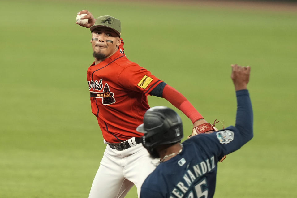 Atlanta Braves' Arcia, top, makes a double play at second base in the seventh inning of a baseball game against Seattle Mariners' Teoscar Hernandez, bottom, Friday, May 19, 2023, in Atlanta. (AP Photo/Brynn Anderson)