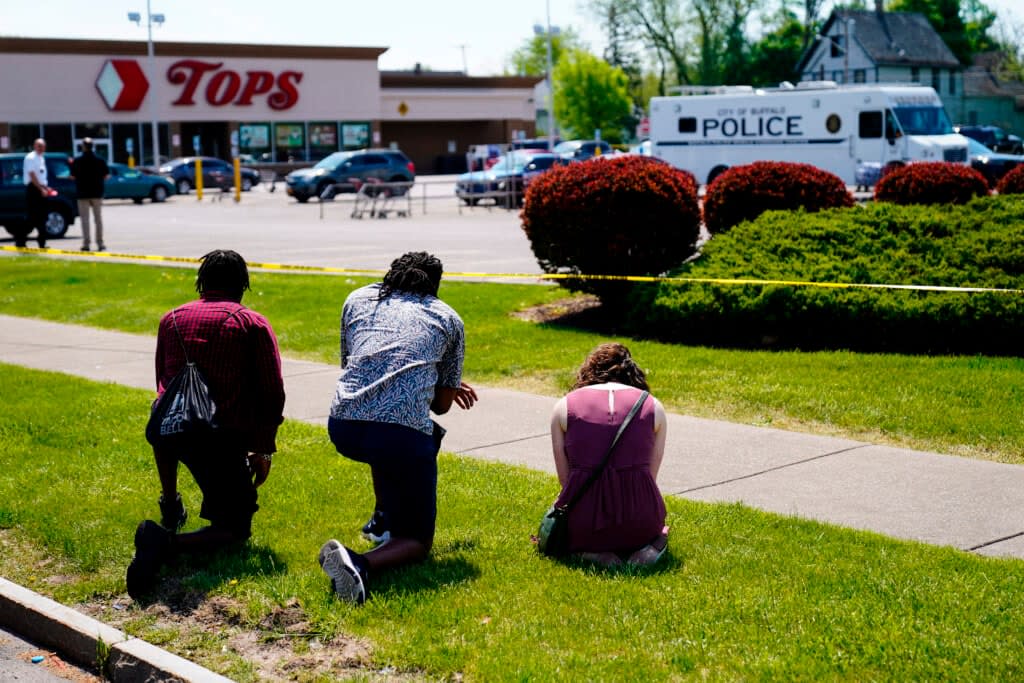 People pray outside the scene of a shooting where police are responding at a supermarket, in Buffalo, N.Y., May 15, 2022. (AP Photo/Matt Rourke, File)