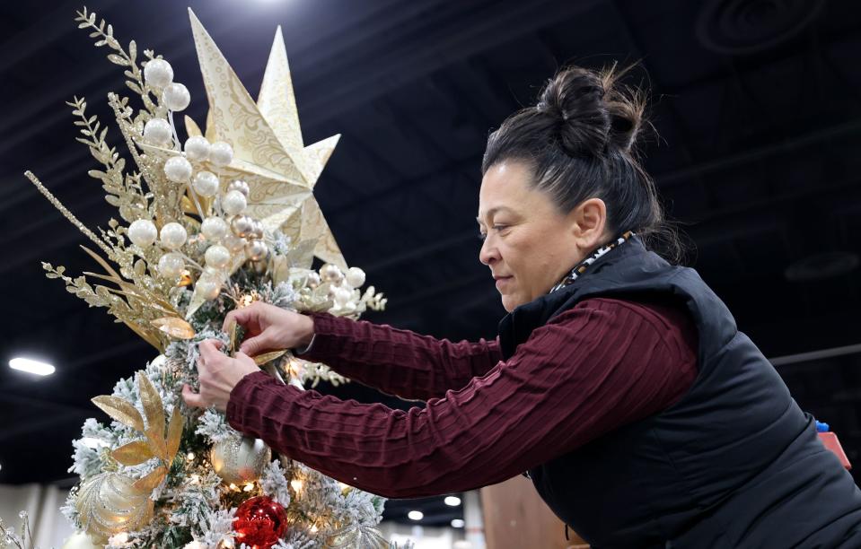 Becky Yamasaki, Festival of Trees executive board member, puts finishing touches on a tree decorated in honor of Afu Fiefia at the 53rd annual Festival of Trees to benefit Intermountain Primary Children’s Hospital patients, at the Mountain America Expo Center in Sandy on Monday, Nov. 27, 2023. Fiefia, 17, was diagnosed with Ewing sarcoma in 2021 and has been in remission for eight months.