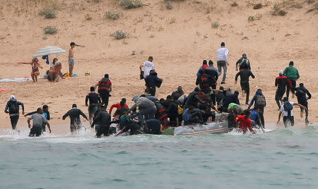 Migrants disembark from a dinghy at "Del Canuelo" beach after they crossed the Strait of Gibraltar sailing from the coast of Morocco, in Tarifa, southern Spain, July 27, 2018. REUTERS/Jon Nazca