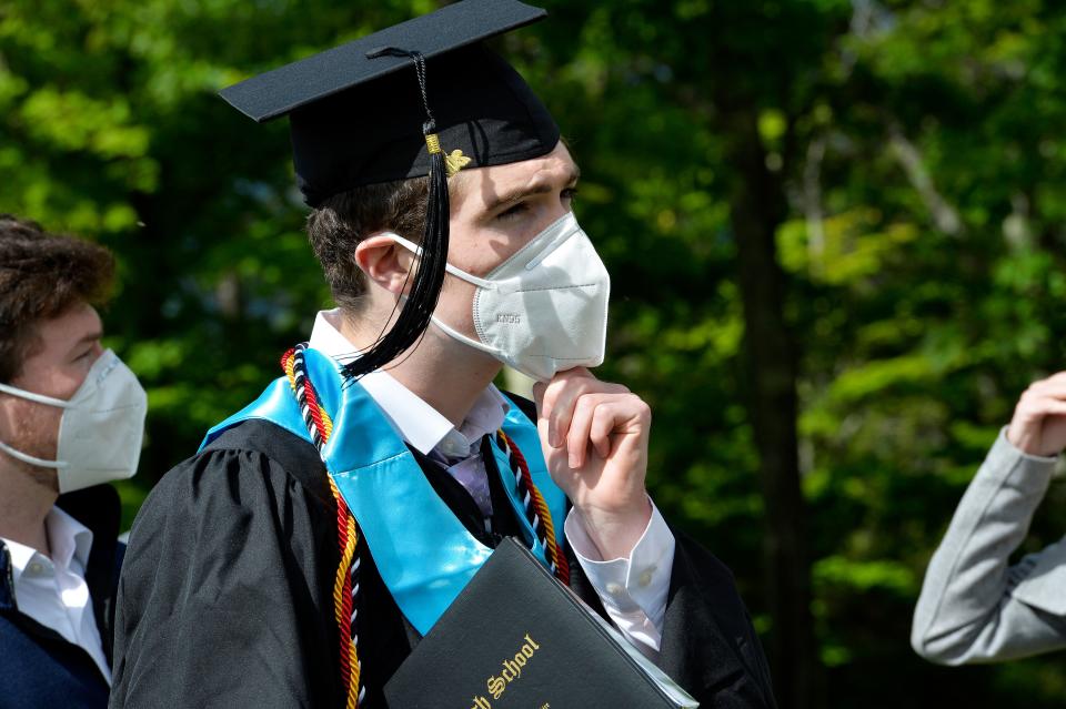A student puts his mask back on after taking family photos during the Kenneth High School Class of 2020 Commencement Exercises at Cranmore Mountain in North Conway, New Hampshire on June 13, 2020. - The unique graduation was a way to follow health guidelines for Covid-19 and allow the students to have their graduation day. (Photo by Joseph Prezioso / AFP) (Photo by JOSEPH PREZIOSO/AFP via Getty Images)