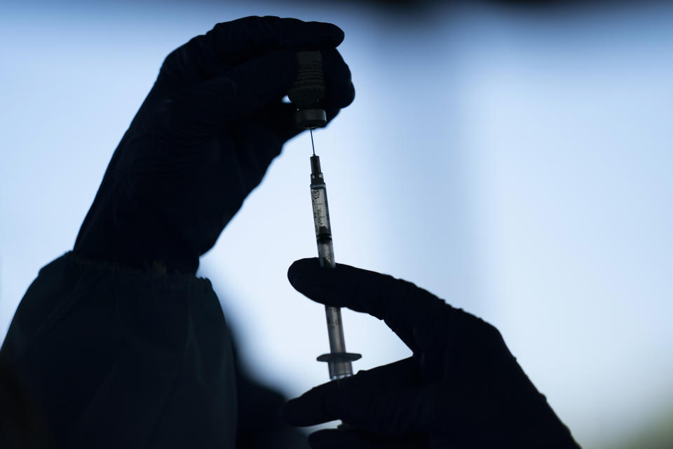 FILE - A medical staff member prepares the Pfizer-BioNTech COVID-19 vaccine at Tudor Ranch in Mecca, Calif. on Jan. 21, 2021. Merriam-Webster has declared vaccine its 2021 word of the year. (AP Photo/Jae C. Hong, File)