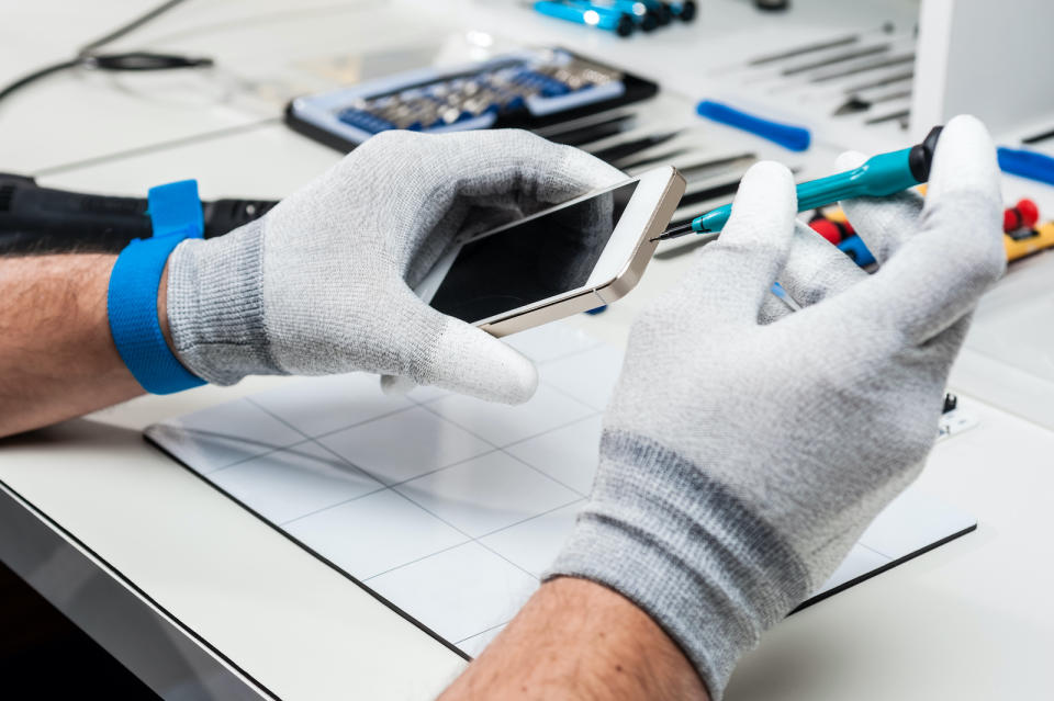 Technician replacing the screen of a used smartphone