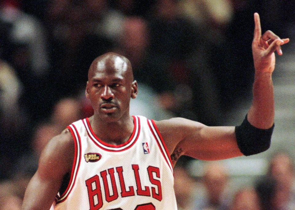 Chicago Bulls guard Michael Jordan signals to his teammates during the first quarter of Game 5 of the NBA finals in Chicago, Friday, June 12, 1998. (AP Photo/Beth A. Keiser)