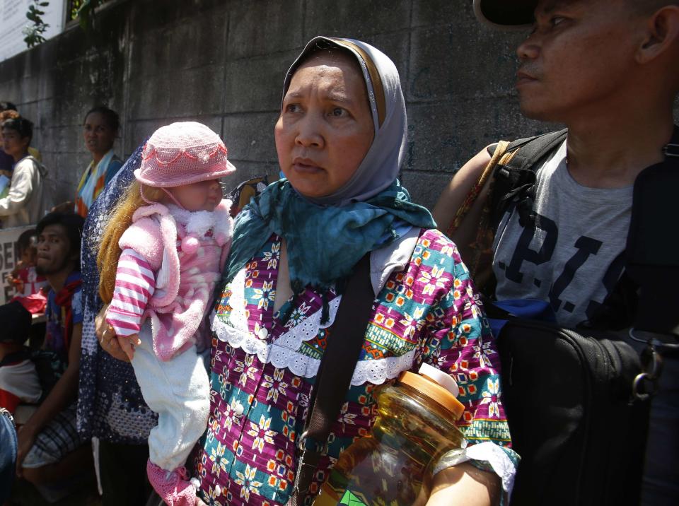 A woman joins other residents that were forced to evacuate a village due to fighting between government soldiers and Muslim rebels from the Moro National Liberation Front (MNLF) in Zamboanga city in southern Philippines