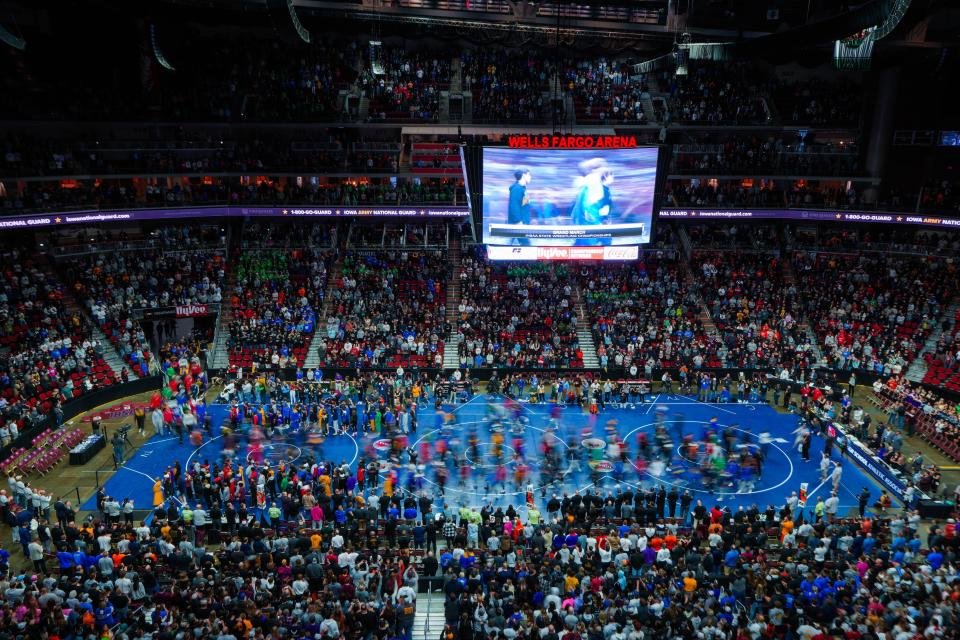 Athletes walk in the grand march before the championship rounds of the Iowa high school state wrestling tournament at Wells Fargo Arena in Des Moines on Saturday, Feb. 18, 2023.