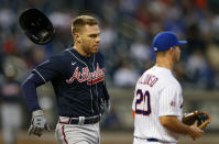 Atlanta Braves first baseman Freddie Freeman, left, loses his helmet running to first base against the New York Mets during the fourth inning of a baseball game Wednesday, June 23, 2021, in New York. (AP Photo/Noah K. Murray)