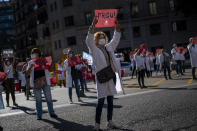 Primary care workers hold placards that read in Catalan: "Enough", as they take part in a protest against their working conditions during a strike in Barcelona, Spain, Tuesday, Oct. 13, 2020. Various regions in Spain, including northern Navarra and northeastern Catalonia, are either planning or implementing fresh restrictions against the spread of the new coronavirus. (AP Photo/Emilio Morenatti)