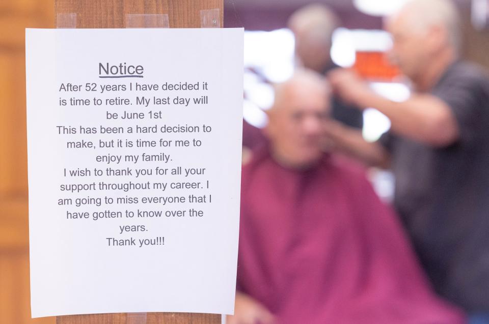 Marvin Harstine, who has run Canton South Barbers for more than 50 years, is retiring June 1. He cuts customer Howard Walters' hair behind a note he has posted for his longtime customers.