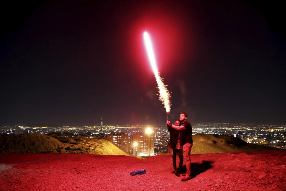 In this Tuesday, March 17, 2020 photo, Iranians light fireworks during a celebration, known as "Chaharshanbe Souri," or Wednesday Feast, marking the eve of the last Wednesday of the solar Persian year, in Tehran, Iran. (AP Photo/Ebrahim Noroozi)