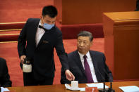 Chinese President Xi Jinping watches as an attendant wearing a face mask refills his glass during an event to honor some of those involved in China's fight against COVID-19 at the Great Hall of the People in Beijing, Tuesday, Sept. 8, 2020. Chinese leader Xi Jinping is praising China's role in battling the global coronavirus pandemic and expressing support for the U.N.'s World Health Organization, in a repudiation of U.S. criticism and a bid to rally domestic support for Communist Party leadership. (AP Photo/Mark Schiefelbein)