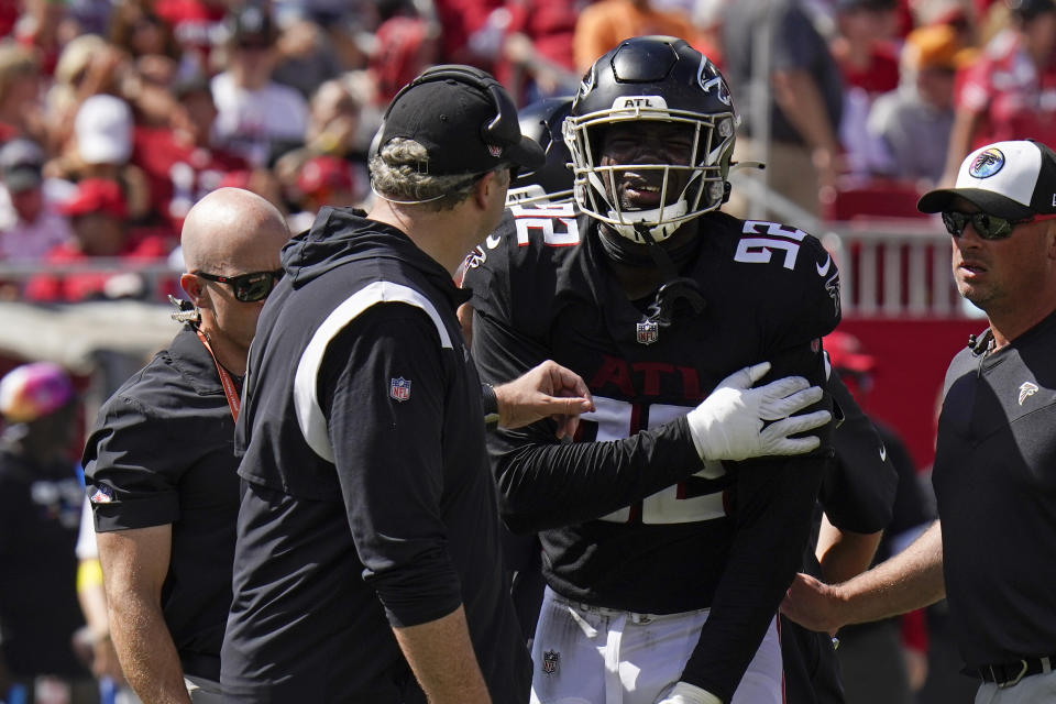 Atlanta Falcons head coach Arthur Smith, left, checks on injured Atlanta Falcons linebacker Adetokunbo Ogundeji (92) during the second half of an NFL football game against the Tampa Bay Buccaneers Sunday, Oct. 9, 2022, in Tampa, Fla. (AP Photo/Chris O'Meara)