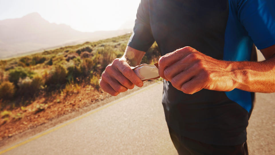 Man opening energy gel during run