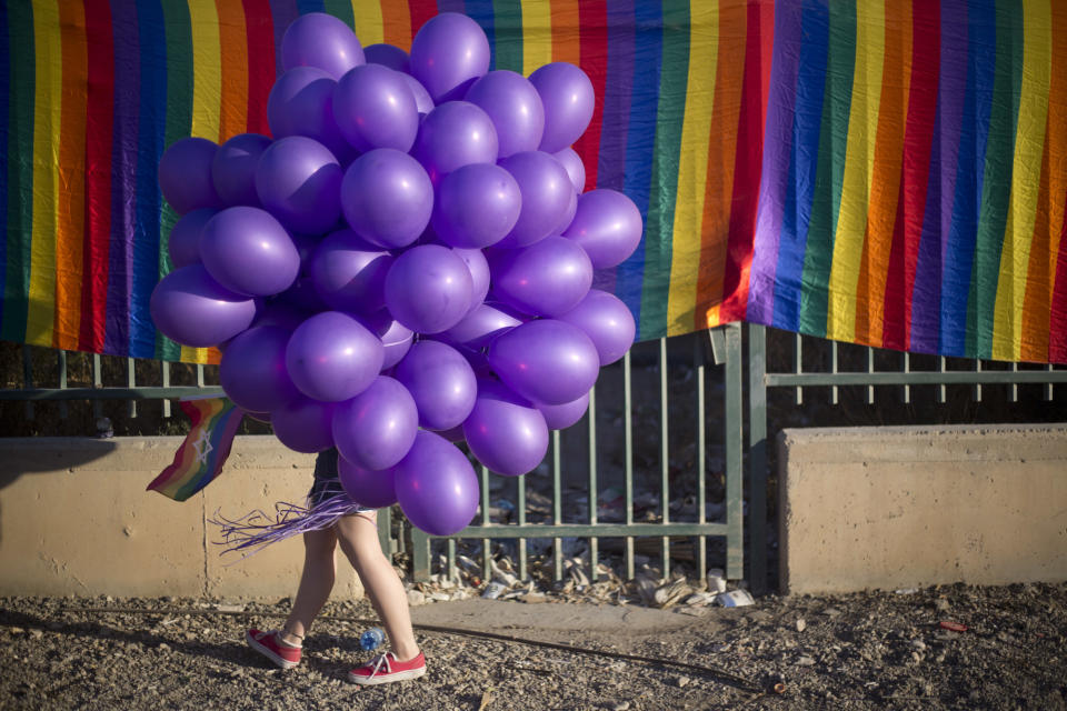 <p>Bei der ersten Gay Pride Parade im israelischen Beersheba hüllt sich eine Teilnehmerin in lila Luftballons. Rund 3.500 Menschen nahmen an dem Umzug teil. (Bild: AP Photo/Ariel Schalit) </p>