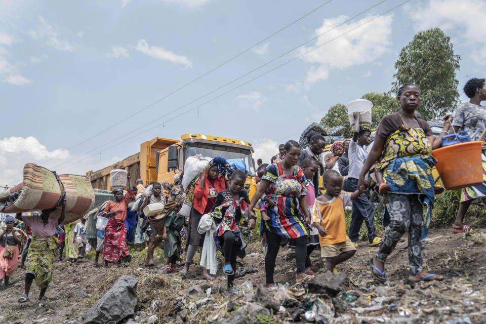 Thousands who are fleeing the ongoing conflict between government forces and M-23 rebels reach the entrance the Democratic Republic of Congo eastern city of Goma Wednesday, Feb. 7, 2024. (AP Photo/Moses Sawasawa)