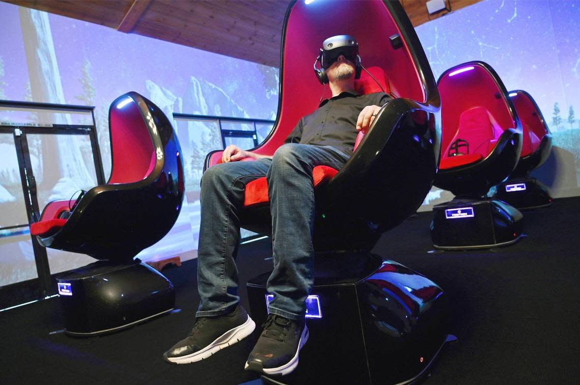 Yosemite Cinema co-owner Matt Sconce demonstrates the viewer’s virtual reality experience in a motion pod chair which slowly rotates and tilts while watching Experience Yosemite at Yosemite Cinema in Oakhurst, Monday, July 18, 2022.