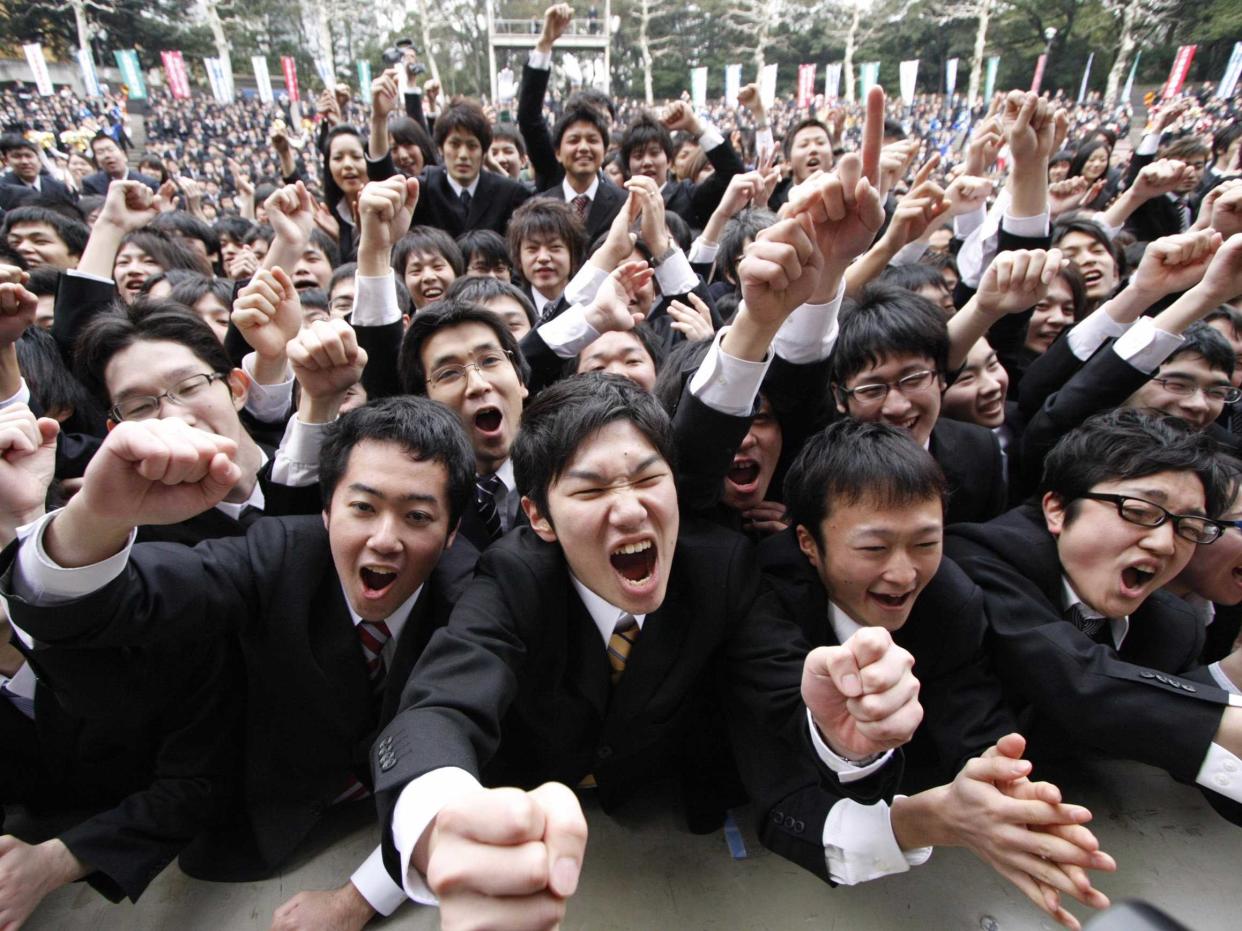 Japanese college students raise their fists at a job-hunting rally in Tokyo February 5, 2009. Some 3,000 students from business schools kicked off their efforts to job-hunt and held a morale-boosting rally. 