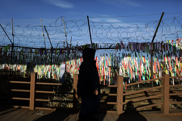 A visitor walks past prayer ribbons hanging on a barbed-wire fence at the Imjingak pavilion near the demilitarized zone (DMZ) in Paju, South Korea. North Korean media has reported that an inter-Korean communication line was reopened at the border village of Panmunjom in response to South Korea’s unification minister Cho Myoung-gyon proposing holding high-level talks with North Korea ahead of winter Olympics on Feb. 9. (Photo by Chung Sung-Jun/Getty Images)