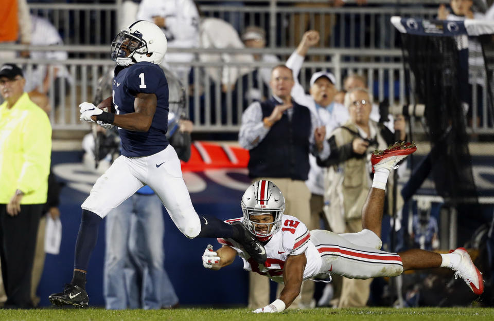 Penn State's KJ Hamler (1) runs in for a touchdown after a catch as Ohio State's Isaiah Pryor (12) goes for the tackle during the first half of an NCAA college football game in State College, Pa., Saturday, Sept. 29, 2018. (AP Photo/Chris Knight)