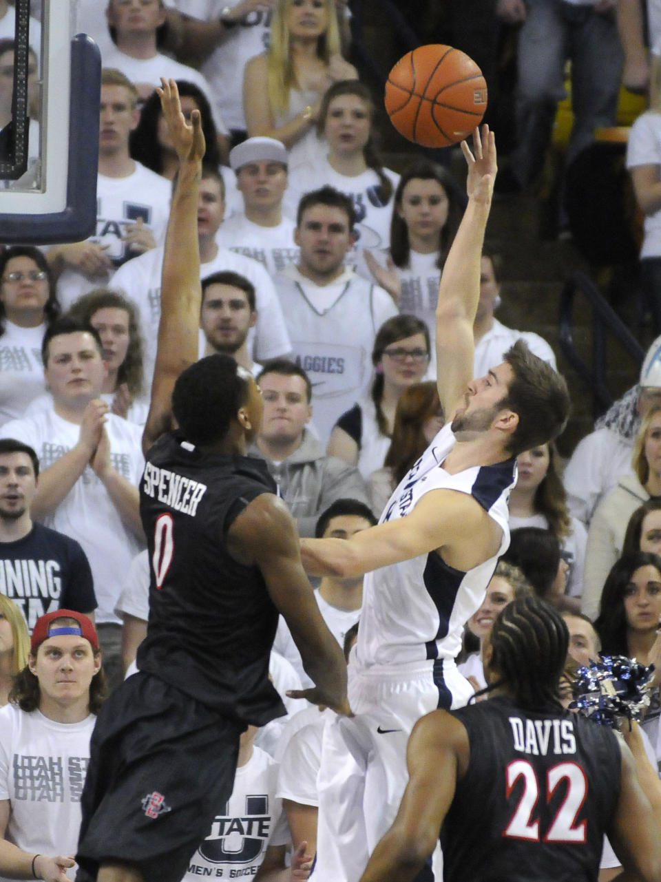 Utah State guard Preston Medlin takes a shot as San Diego State forward Skylar Spencer (0) and forward Josh Davis (22) defend during the first half of an NCAA college basketball game Saturday, Jan. 25, 2014, in Logan, Utah. (AP Photo/Eli Lucero)