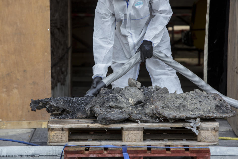 A worker cleans debris, during preliminary work to repair the fire damage at the Notre-Dame de Paris Cathedral, in Paris, France, Wednesday, July 24, 2019. (AP Photo/Rafael Yaghobzadeh, Pool)