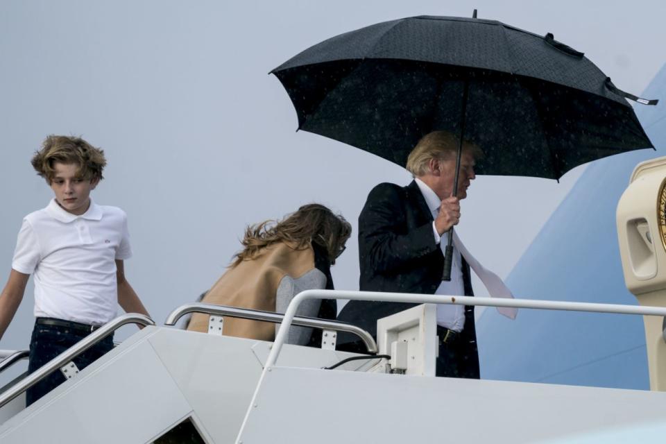 <em>Ungentlemanly – Trump was accused of being ungentlemanly after hogging an umbrella and leaving Melania and Barron out in the cold (Picture: AP)</em>