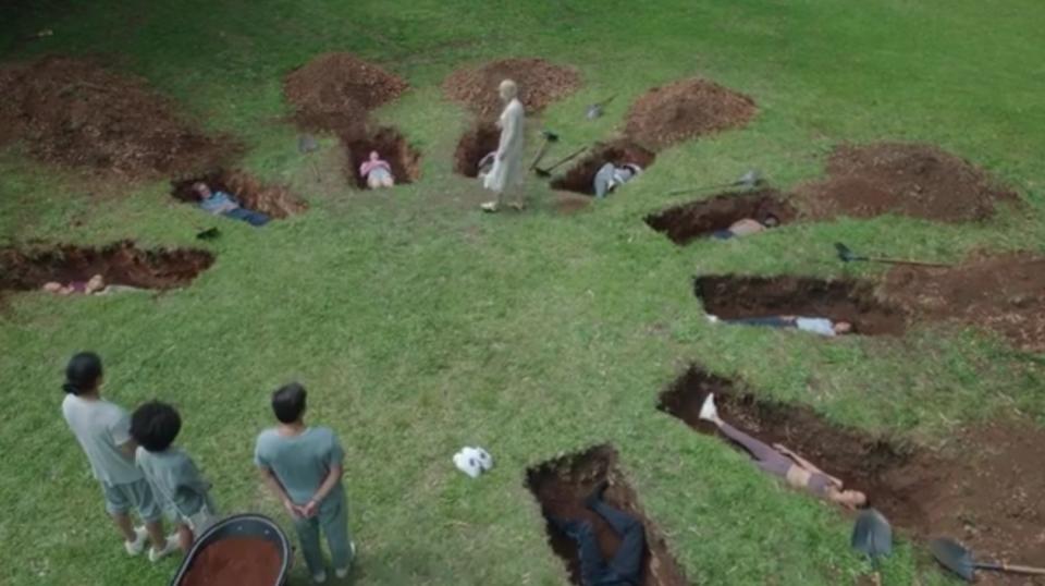 The guests lay in open graves set out in a circle while Tranquillum staff stand above them