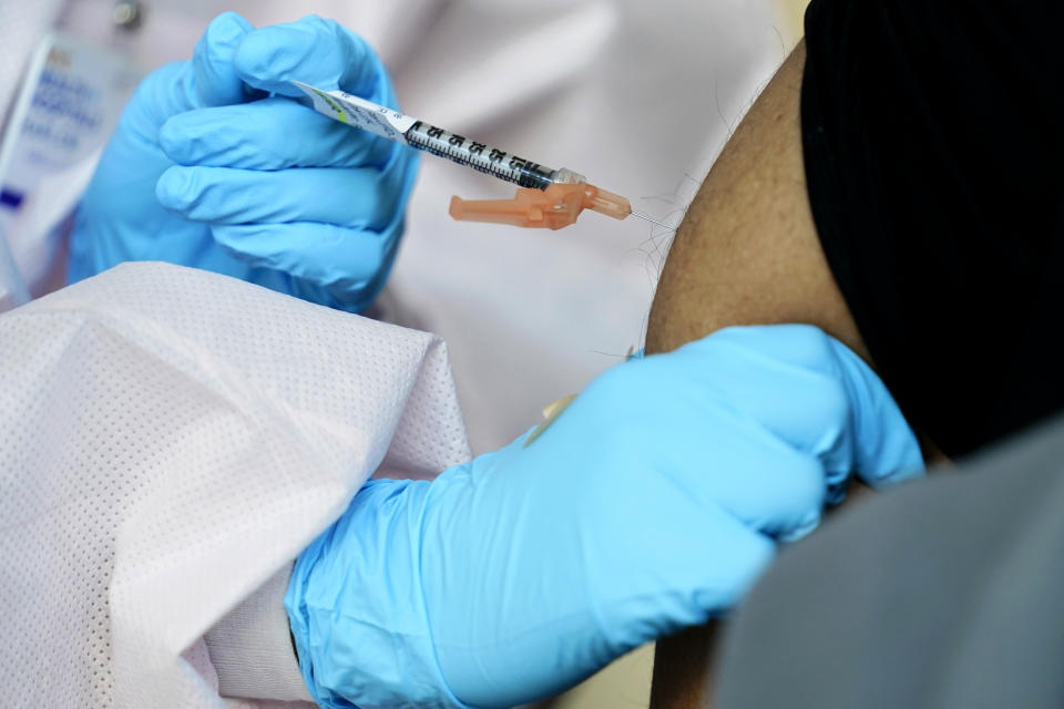 A man receives a COVID-19 vaccine in the Harlem section of New York, Thursday, Feb. 25, 2021. Rev. Al Sharpton and other community leaders were vaccinated at NYC Health + Hospitals Harlem Hospital as part of an effort to increase vaccine education in communities of color. (AP Photo/Seth Wenig)