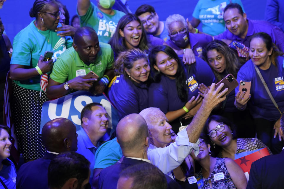 FILE - President Joe Biden takes a photo with people after speaking at a rally hosted by the Democratic National Committee at Richard Montgomery High School, Aug. 25, 2022, in Rockville, Md. (AP Photo/Evan Vucci, File)