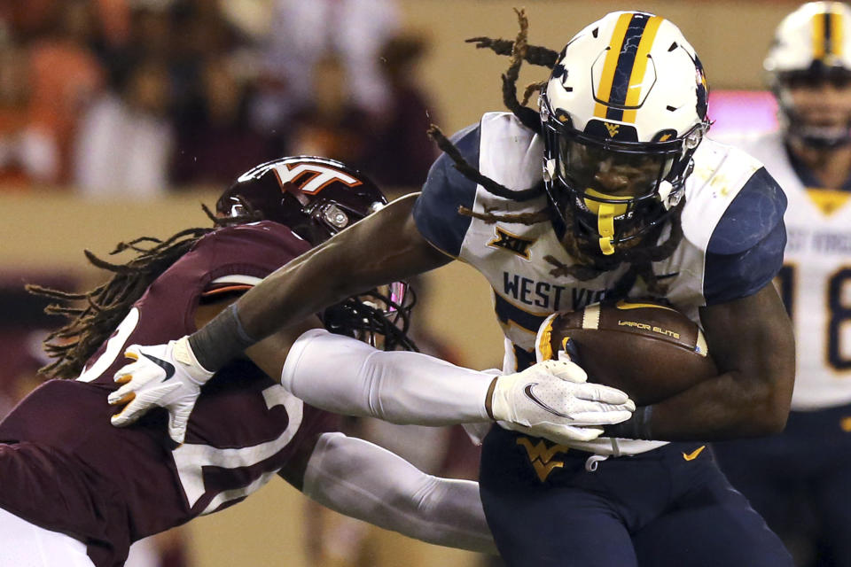 Virginia Tech's Jalen Stroman (26) causes West Virginia running back Tony Mathis Jr. (24) to fumble for a turnover during the first half of an NCAA college football game Thursday, Sept. 22, 2022, in Blacksburg, Va. (Matt Gentry/The Roanoke Times via AP)