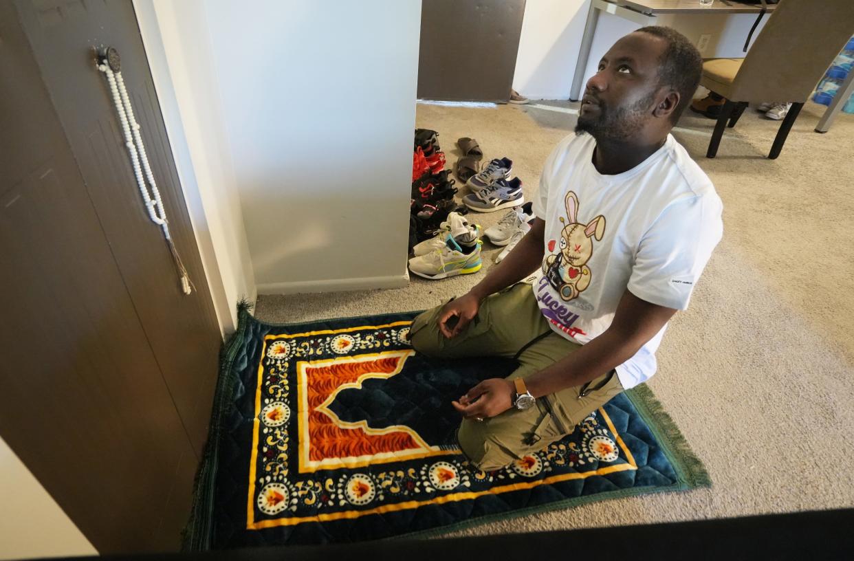 Amadou Kane, an asylum seeker from Mauritania, prays in his Southeast Side living room in March 2023.