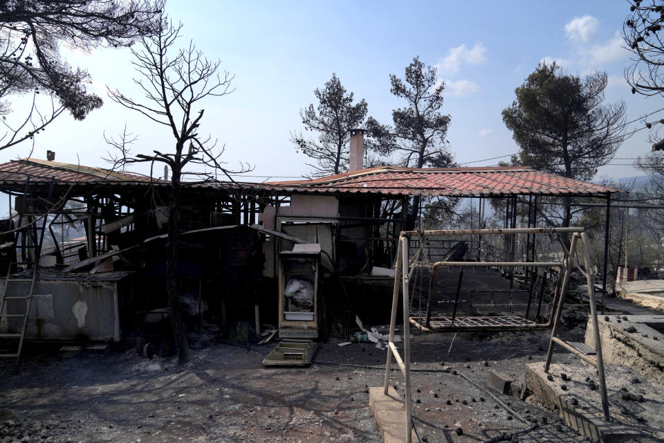 A burnt house during a wildfire in Thea area some 60 kilometers (37 miles) northwest of Athens, Greece, Thursday, Aug. 19, 2021. A major wildfire northwest of the Greek capital devoured large tracts of pine forest for a third day and threatened a large village as hundreds of firefighters, assisted by water-dropping planes and helicopters, battled the flames Wednesday. (AP Photo/Thanassis Stavrakis)