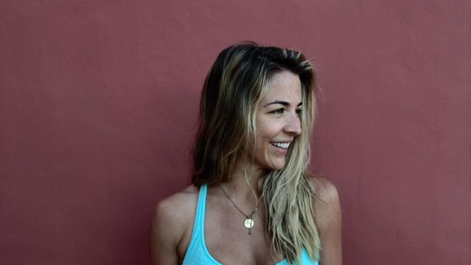 woman posing against wall in blue bikini 