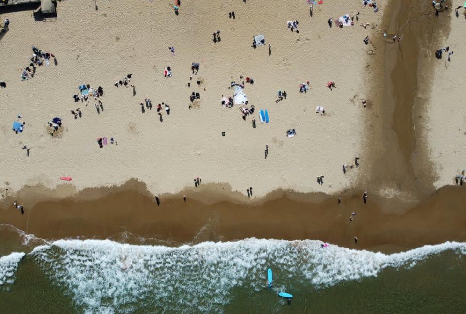 People enjoy the warm weather on Tynemouth Longsands beach, near Tynemouth in Tyne and Wear (Owen Humphreys/PA) (PA Wire)