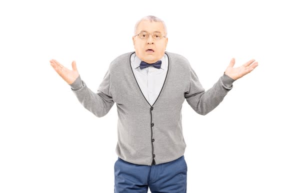 A senior man in a vest and bowtie shrugging his shoulders and raising his arms.