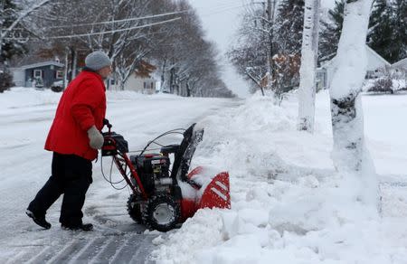 Tom Sargent pushes his snowblower up his driveway in Bangor, Maine, U.S. December 30, 2016. REUTERS/Ashley Conti