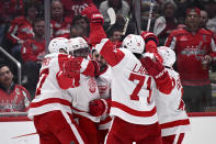 Detroit Red Wings left wing David Perron (57) celebrates his goal with center Dylan Larkin (71), left wing J.T. Compher, left, and others during the second period of an NHL hockey game against the Washington Capitals, Tuesday, March 26, 2024, in Washington. (AP Photo/Nick Wass)