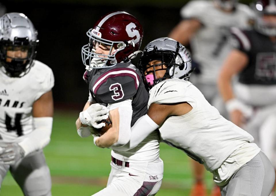 A Harrisburg defender tires to stop State College Ty Salazer as makes a catch and runs with the ball during the game on Friday, Oct. 13, 2023.