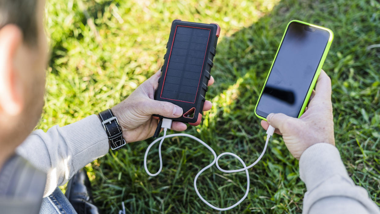   Someone holds a mobile device and a power bank in each hand.  