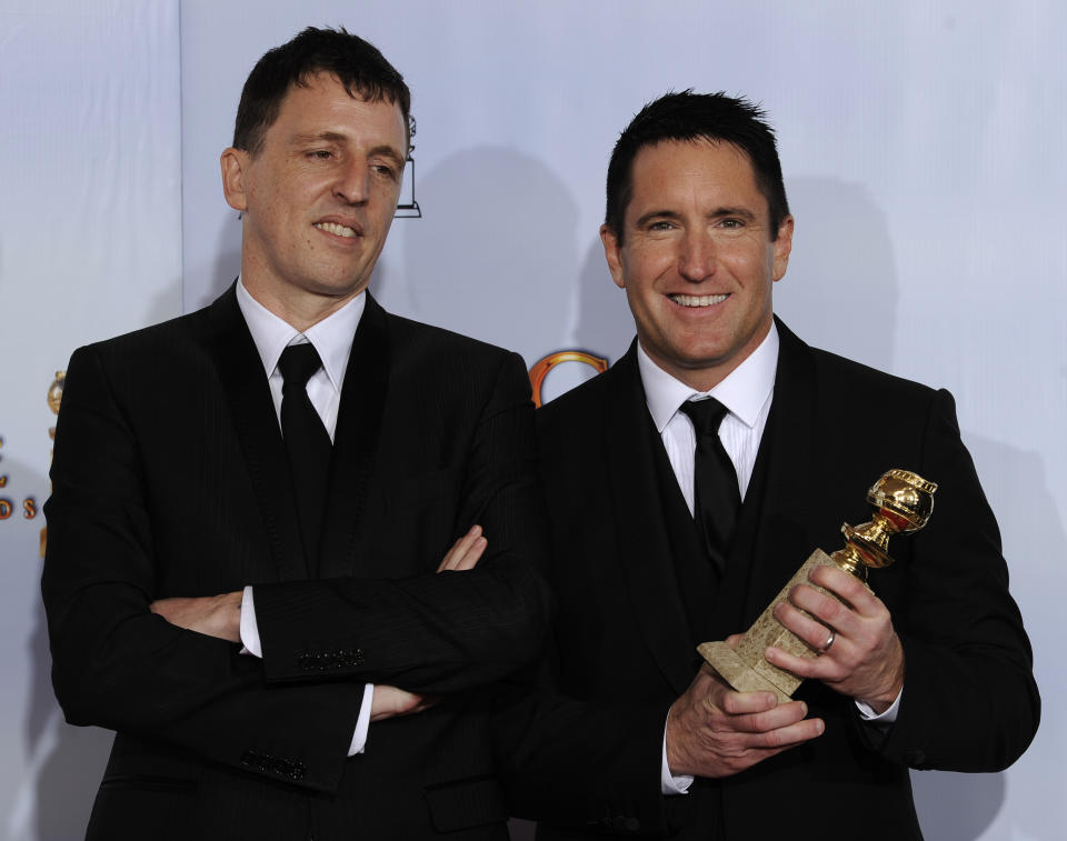 CORRECTS NOMINATION TO OSCARS - FILE - In this Jan. 16, 2011 file photo, Trent Reznor, right, and Atticus Ross pose with the trophy they won for Best Original Score - Motion Picture for the film "The Social Network," at the Golden Globe Awards in Beverly Hills, Calif. On Monday, March 15, Reznor and Ross were nominated for 2 Oscar nominations for best original score for "Mank" and "Soul." (AP Photo/Mark J. Terrill, File)