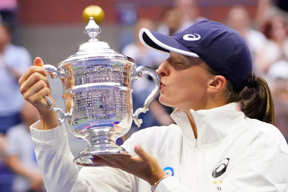 Sept. 10: Iga Swiatek celebrates with the championship trophy after defeating Ons Jabeur.