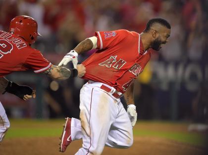 Josh Hamilton (left) tries to rip the jersey off Howie Kendrick after Kendrick's sacrifice fly won the game. (AP)