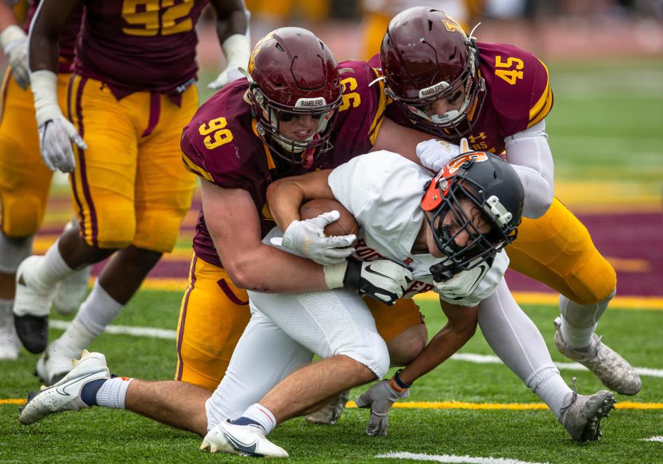 Rochester’s Parker Gillespie (24) gets crushed by Loyola Academy’s Brooks Bahr (99) and Jamie McCabe (45) in the first half at Hoerster Field in Wilmette, Ill., Saturday, September 4, 2021. [Justin L. Fowler/The State Journal-Register] 