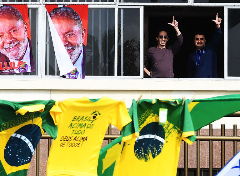 Los partidarios del candidato presidencial brasileño Luiz Inacio Lula da Silva muestran la "L de Lula" mientras los partidarios del presidente brasileño Jair Bolsonaro comienzan a reunirse ante una caravana a lo largo de la playa de Copacabana en Río de Janeiro para conmemorar el 200 aniversario de la independencia de Brasil, el 7 de septiembre de 2022