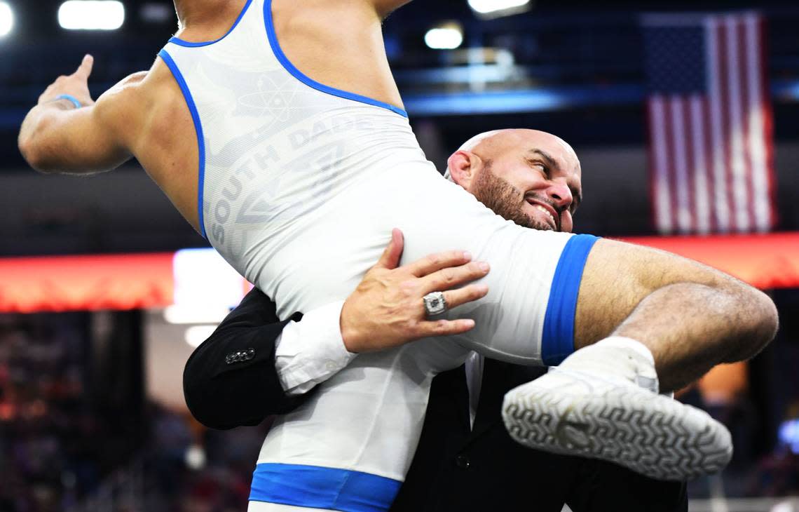 Luis Acevedo leaps into the arms of South Dade coach Victor Balmeceda after winning Class 3A 120-pound state title match on Saturday at Silver Spurs Arena in Kissimmee.