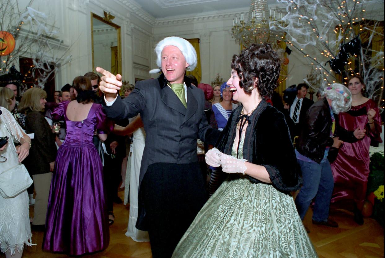 President Clinton and Hillary Clinton in costume with guests at a the First Lady's birthday party and Halloween celebration at the White House. The President and First Lady are dressed as President James Madison and Dolley Madison in 18th century style wigs and attire.