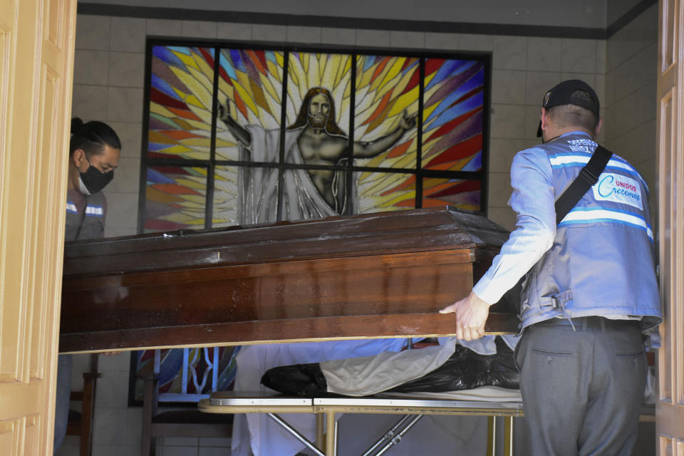 Healthcare workers carry an empty coffin into the San Jose nursing home to recover the body of a resident who is suspected to have died from COVID-19, in Cochabamba, Bolivia, Thursday, July 16, 2020. A special police unit collected 420 bodies over the preceding five days in two Bolivian cities, and 80% to 90% of the deceased were thought to have succumbed to COVID-19, authorities said Tuesday. (AP Photo/Dico Solis)