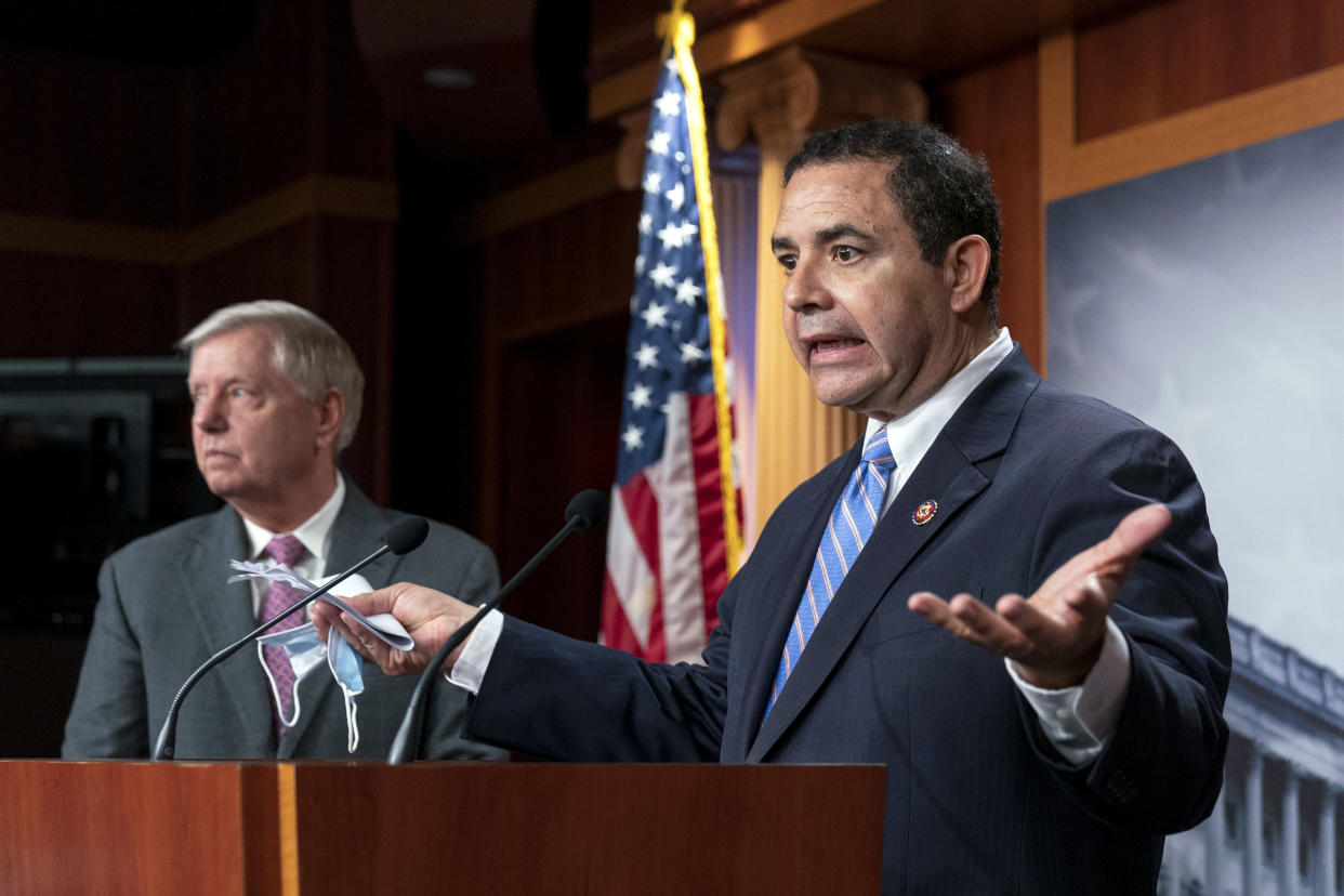 Rep. Henry Cuellar, D-Texas, speaks at a podium next to Sen. Lindsey Graham, R-S.C.